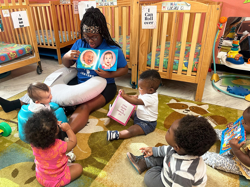 In a nursery, a woman captivates a group of babies with a story, encouraging imagination and connection through reading.